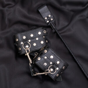 Leather handcuffs and stack on black background. Accessories for adult sexual game. BDSM outfit.